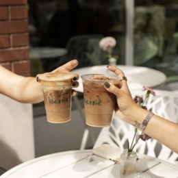 two hands holding cocktails